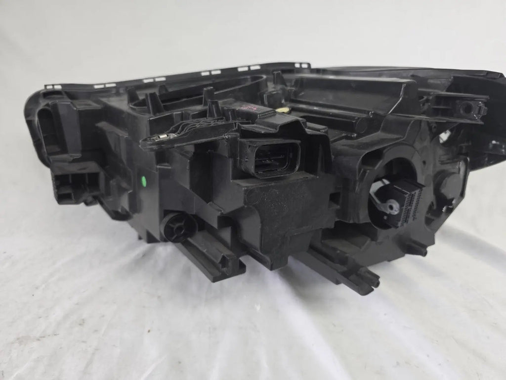 Used genuine BMW Adaptive LED headlight for X1 F48 LCI (facelift) model. This right-side OEM headlamp, part number 5A01178, is equipped with adaptive lighting technology for improved night visibility and cornering performance. The image displays the original right Adaptive LED headlight in used condition, showing the clear lens, mounting brackets, and electrical connectors — an ideal OEM replacement for BMW X1 F48 LCI vehicles.

