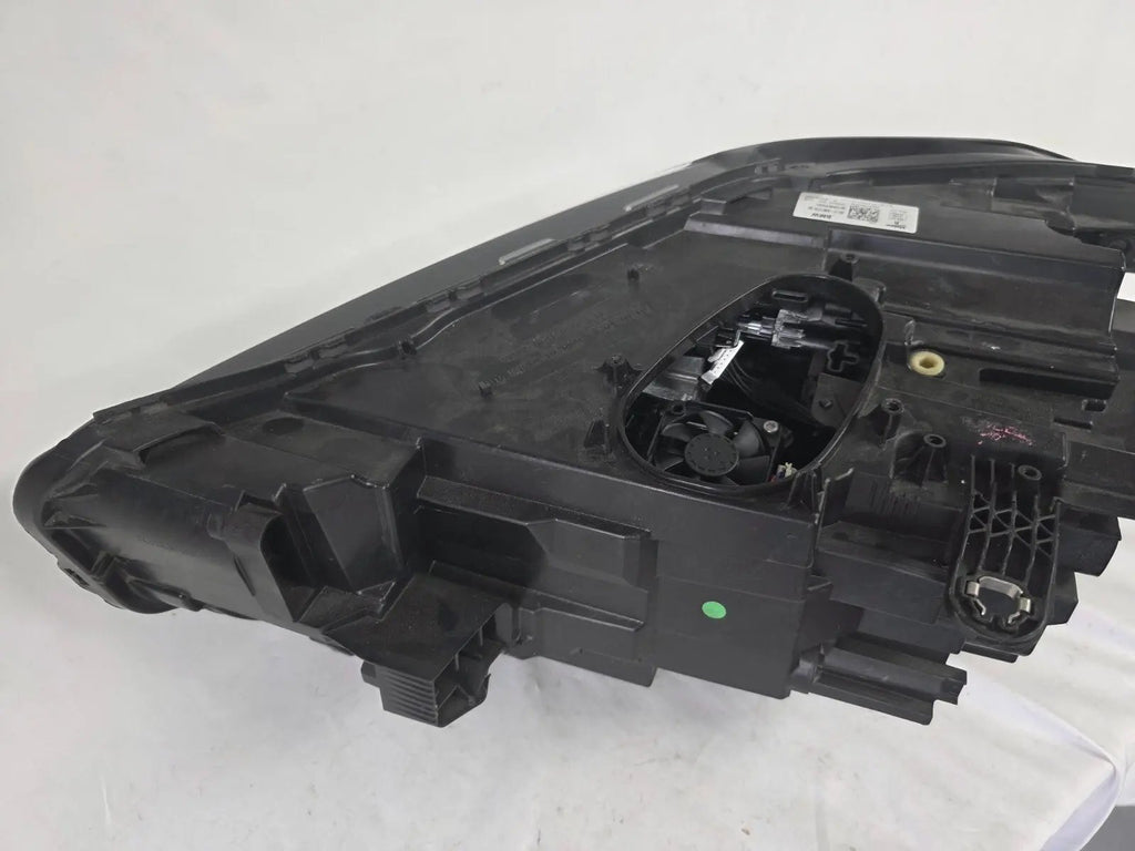 Used genuine BMW Adaptive LED headlight for X1 F48 LCI (facelift) model. This right-side OEM headlamp, part number 5A01178, is equipped with adaptive lighting technology for improved night visibility and cornering performance. The image displays the original right Adaptive LED headlight in used condition, showing the clear lens, mounting brackets, and electrical connectors — an ideal OEM replacement for BMW X1 F48 LCI vehicles.

