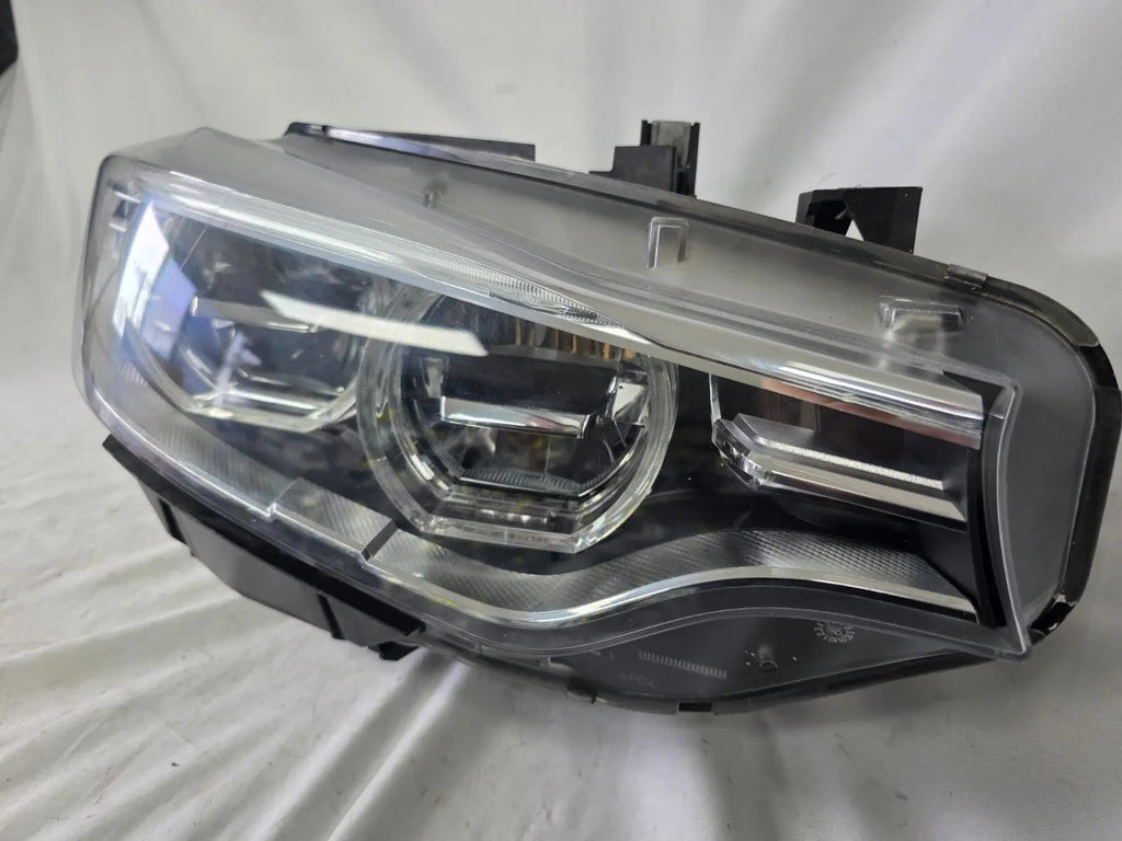 Genuine used BMW Adaptive LED headlight for 4 Series models F32, F33, F36, F80 LCI, F82, and F83. This right-side OEM headlamp, part number 7377842, is designed with adaptive lighting technology for improved visibility and performance. The image highlights the complete original headlight unit in used condition, including the clear lens, mounting points, and electrical connectors — ideal for replacement on compatible BMW models.