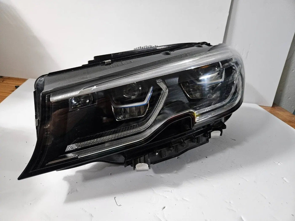 Genuine used BMW Laser headlight for 3 Series models G20 and G21. This left-side OEM headlamp, part number 9481707, features high-performance laser lighting technology for superior road visibility and driving precision. The image showcases the original left laser headlight in used condition, clearly showing the lens structure, housing, and connector ports — ideal for replacing a damaged headlamp on compatible BMW 3 Series vehicles.

