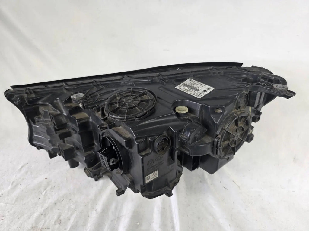 Used genuine BMW Laser headlight for 7 Series models G11 and G12. This right-side OEM headlamp, part number 7465606, features advanced laser lighting technology for superior visibility and performance. The image shows the original BMW right laser headlight in used condition, highlighting the detailed lens design, housing structure, and connector ports — ideal for high-end replacement or repair on compatible 7 Series vehicles.

