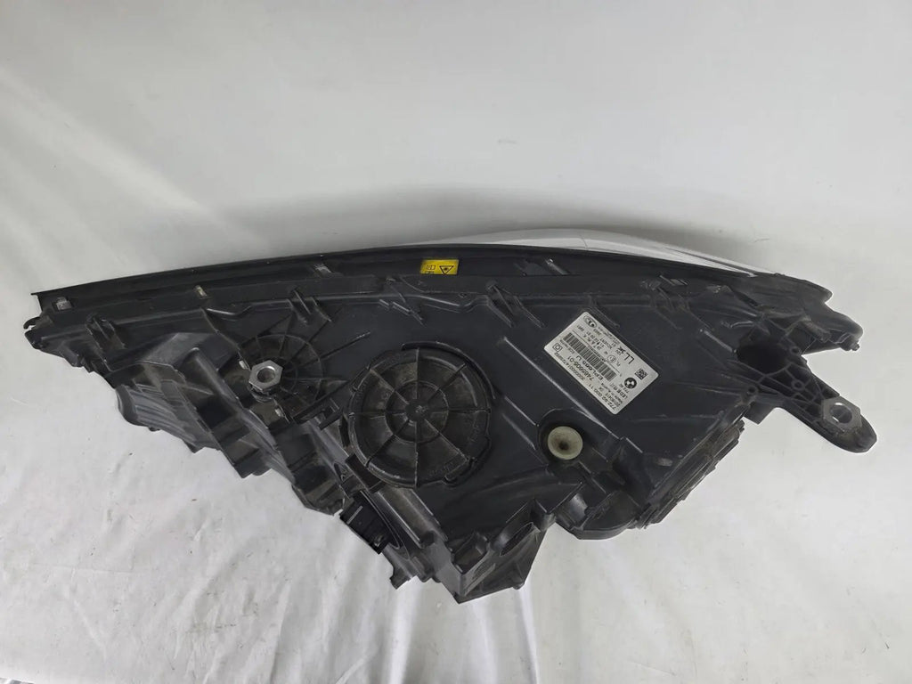 Used genuine BMW Laser headlight for 7 Series models G11 and G12. This right-side OEM headlamp, part number 7465606, features advanced laser lighting technology for superior visibility and performance. The image shows the original BMW right laser headlight in used condition, highlighting the detailed lens design, housing structure, and connector ports — ideal for high-end replacement or repair on compatible 7 Series vehicles.

