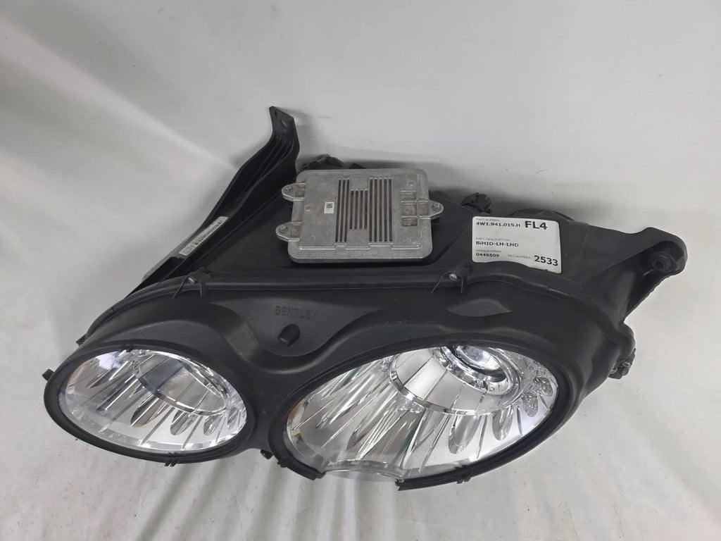 This image shows the left-side headlight for the 2014–2019 Bentley Flying Spur, featuring OEM genuine quality with part number 4W1941015H. This used original headlamp is in excellent condition, offering premium illumination, elegant design, and a precise fit for Bentley’s high-end luxury sedan