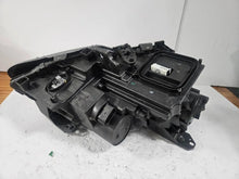 Load image into Gallery viewer, Genuine used Mercedes-Benz Bi-Xenon headlight for GLA-Class model X156. This left-side (LH) OEM headlamp, part number A1569061700, features Bi-Xenon lighting technology for enhanced night visibility and a focused beam pattern. The image shows the original left headlight in used condition, highlighting the lens clarity, projector unit, mounting brackets, and electrical connector — ideal for replacing a damaged headlamp on compatible Mercedes-Benz GLA X156 vehicles.