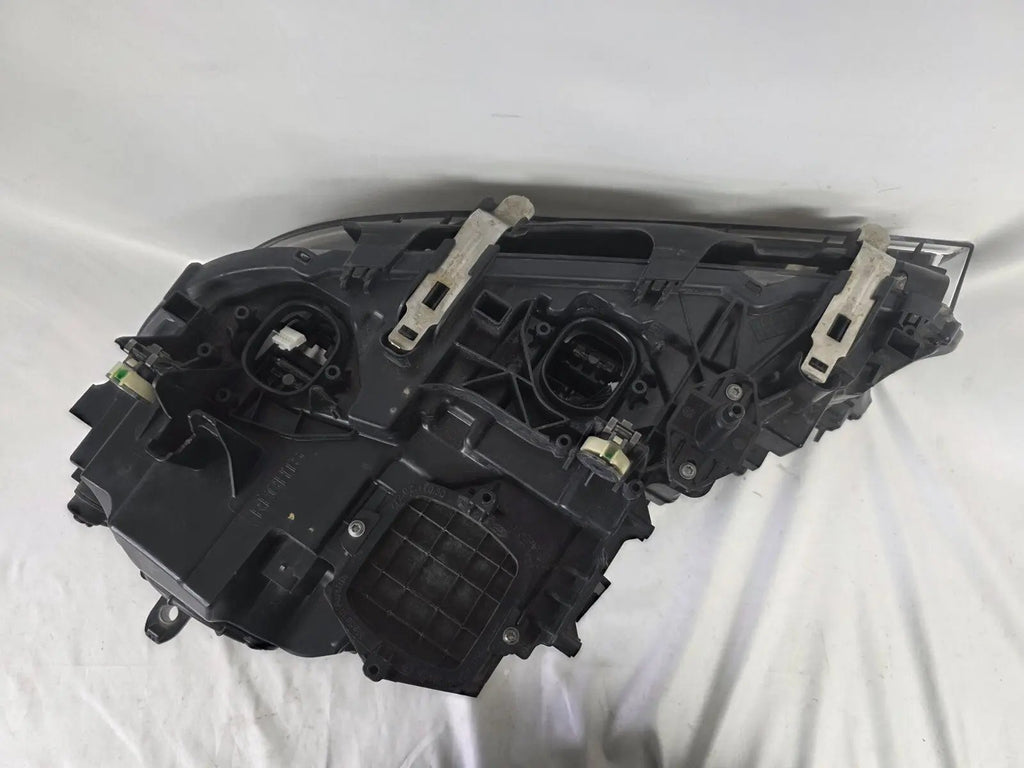 Used genuine BMW Laser headlight for 7 Series models G11 and G12. This right-side OEM headlamp, part number 7465606, features advanced laser lighting technology for superior visibility and performance. The image shows the original BMW right laser headlight in used condition, highlighting the detailed lens design, housing structure, and connector ports — ideal for high-end replacement or repair on compatible 7 Series vehicles.

