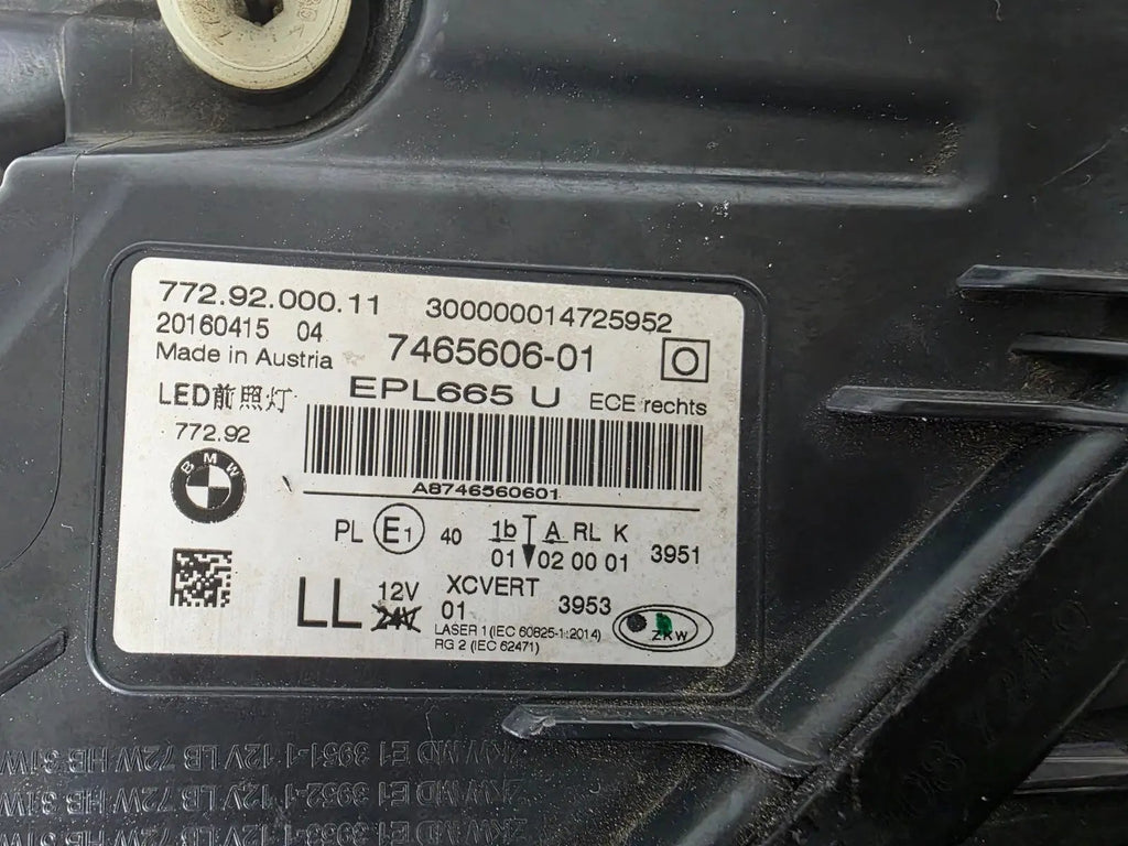 Used genuine BMW Laser headlight for 7 Series models G11 and G12. This right-side OEM headlamp, part number 7465606, features advanced laser lighting technology for superior visibility and performance. The image shows the original BMW right laser headlight in used condition, highlighting the detailed lens design, housing structure, and connector ports — ideal for high-end replacement or repair on compatible 7 Series vehicles.

